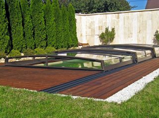 Modell Corona aus der flachen Serie der Schwimmbadüberdachungen hier bestens passend zum Holzboden.