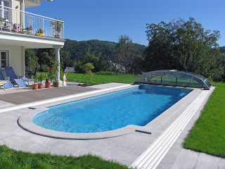 Low swimming pool enclosure ELEGANT with really high trees  above pool cover