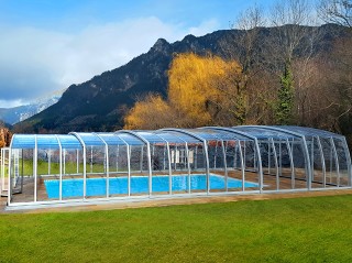 Copertura per piscina Omega in colore argento con le montagne in fondo