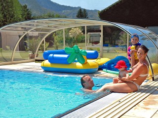 Famiglia si diverte le giornate d’estate sotto la copertura per piscine Tropea NEO