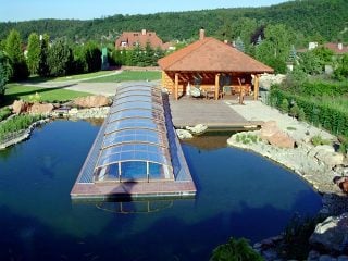 L’abri de piscine IMPERIA en imitation bois va très bien la cabine en bois