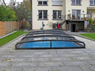 Retractable swimming pool enclosure Riviera protects pool from falling leaves