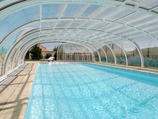 Copertura piscina telescopica lussuosa con profili in alluminio e policarbonato con ampia apertura frontale