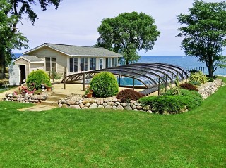 La copertura piscine Elegant con colore telaio bronzo – con la bellissima vista mare