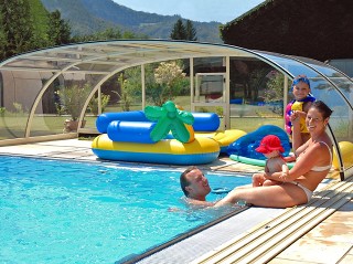 Happy family is enjoing summer days under pool enclosure Tropea NEO 