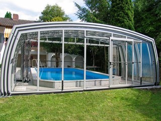 Pool enclosure with open frontal side next to a house