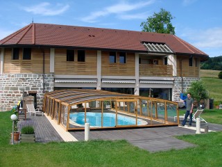 Pool enclosure Venezia with wood imitation goes well with house in the background