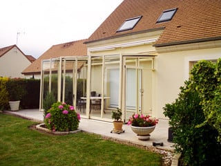 The most exclusive innovative conservatory - retractable patio enclosure CORSO GLASS with white frames complements your home