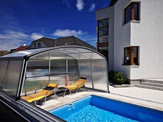 Pool enclosure Venezia in silver color looks great by the modern house