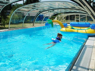 Kids playing in pool covered with TROPEA pool enclosure