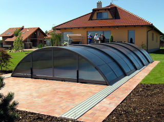 Swimming pool enclosure UNIVERSE, with dark frames and smoked polycarbonate panels
